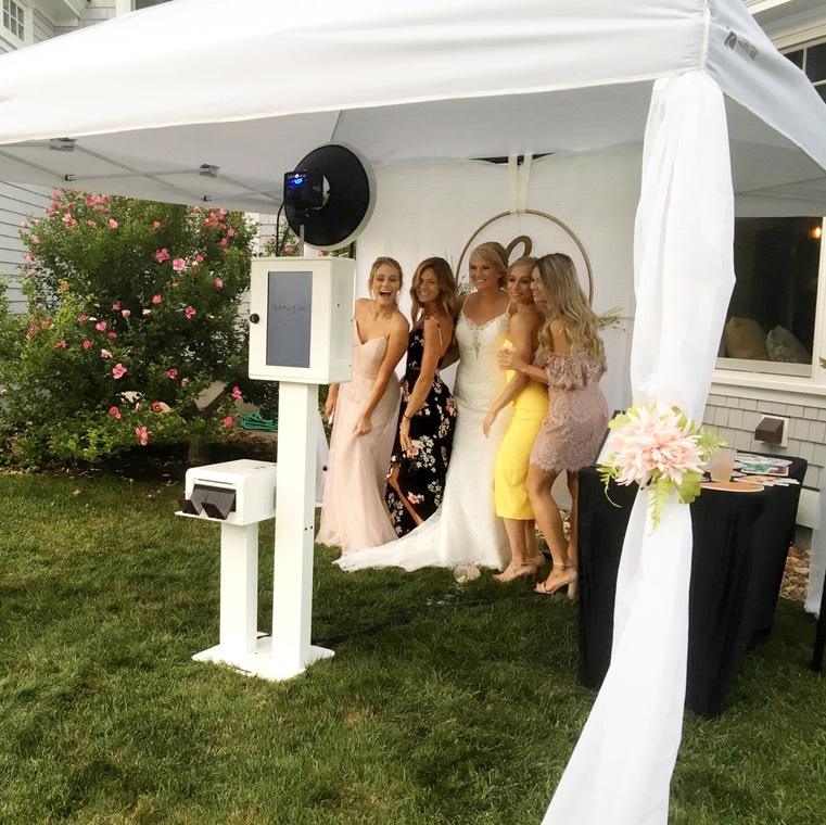 outdoor photo booth under a tent with bride and bridesmaids